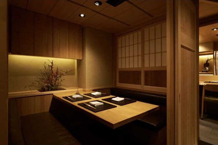 Wood-paneled private dining room with a table set for four at the former Oniku Karyu